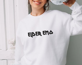 May include: White sweatshirt with the text "Elder Emo" printed in black on the front.