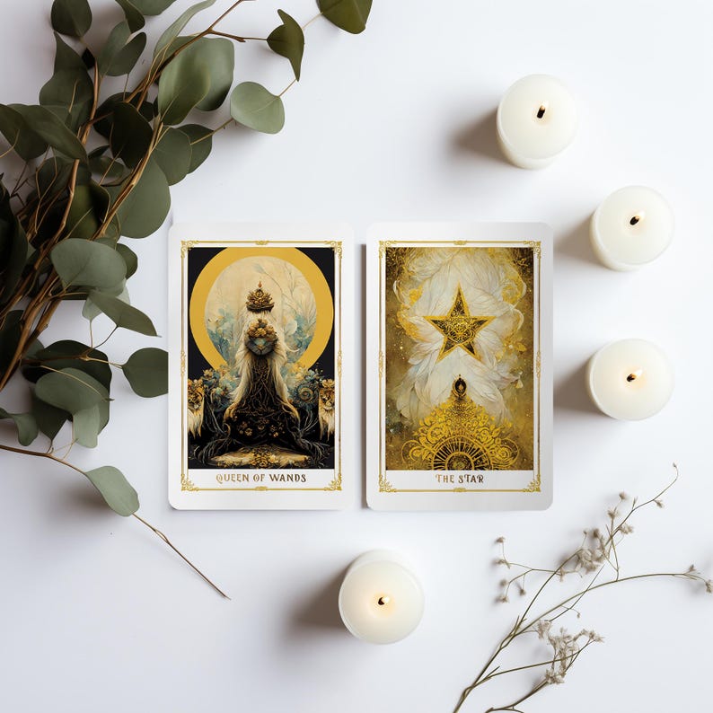 May include: Two tarot cards, "Queen of Wands" and "The Star", with gold and cream illustrations, are displayed. The cards are surrounded by lit white candles and greenery on a white surface. The cards have gold borders.