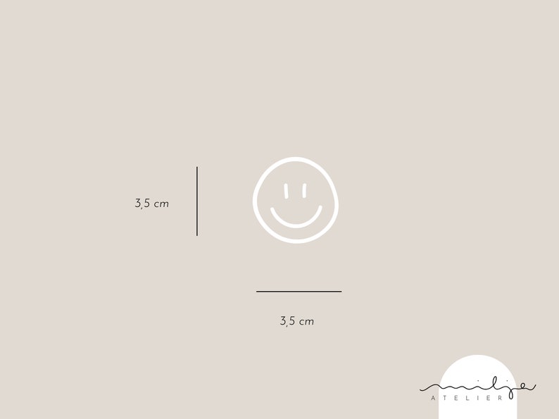 May include: A white smiley face icon on a light gray background. The icon is 3.5 inches wide and 3.5 inches tall. The text "atelier" is written in black below the icon.