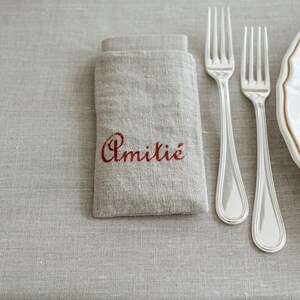 Tovaglia rettangolare con 8 tovaglioli e 8 portatovaglioli in puro lino decorati a stencil.