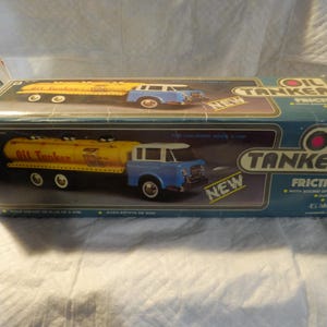 Pode incluir: Um caminh&atilde;o-tanque de &oacute;leo de brinquedo azul e amarelo com motor de fric&ccedil;&atilde;o. A caixa diz "Oil Tanker Friction" e "New".