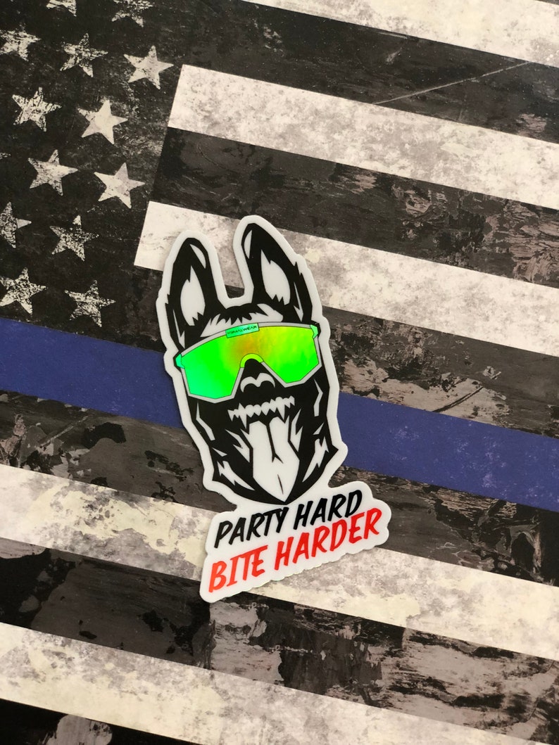 K&ouml;nnte beinhalten: Ein schwarz-wei&szlig;er Aufkleber mit einem Hund, der eine gr&uuml;n-gelbe, schillernde Sonnenbrille tr&auml;gt. Der Aufkleber tr&auml;gt den Text "Party Hard Bite Harder" in Rot.