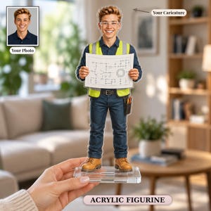 Op de afbeelding: Een gepersonaliseerd acrylfiguur van een persoon in een donkerblauw overhemd, donkerblauwe broek, geel reflecterend vest en bruine werkschoenen. Het figuur houdt een wit papier met een technisch schakelschema vast en heeft een gereedschapstasje.