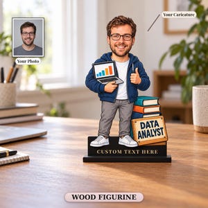 Könnte beinhalten: Eine individuelle Holzfigur, die eine Cartoon-Karikatur eines Mannes mit Brille in blauem Kapuzenpullover, weißem T-Shirt und grauer Hose zeigt. Die Figur hält einen Laptop mit Balkendiagramm neben einem Bücherstapel und einem Schild DATA ANALYST.