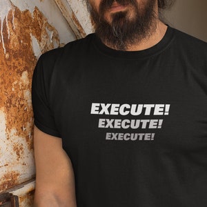 Puede incluir: Una camiseta negra con el texto "EXECUTE! EXECUTE! EXECUTE!" impreso en blanco en la parte delantera.