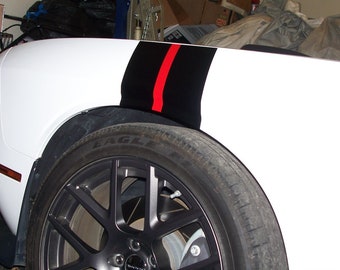 May include: A white car with black and red racing stripes on the side. The car has black alloy wheels and a black tire.