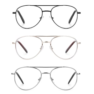 May include: Three pairs of aviator-style eyeglasses with clear lenses. The top pair has a black frame, the middle pair has a gold frame, and the bottom pair has a silver frame. Each pair has dark temples and a double bridge.