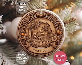 May include: Round wooden ornament with a Florida beach scene, featuring palm trees, dolphins, a lighthouse, and waves. The ornament has a banner with the name "Jones" and the year "2025". The ornament is hanging from a gold string.