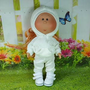 May include: A white doll wearing a white hooded sweatshirt and matching pants. The doll has red hair and large blue eyes.