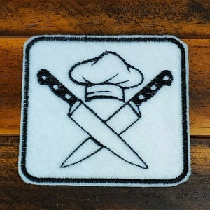 May include: A white embroidered patch with a chef's hat and two crossed kitchen knives. The patch is surrounded by a black border.