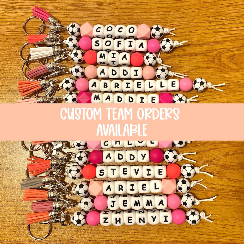 Pu&ograve; includere: Portachiavi con nomi scritti con perline di lettere bianche, intervallati da perline rosa, pesca e pallone da calcio. Ogni portachiavi ha un nappa in vari colori. &Egrave; visibile anche il testo "CUSTOM TEAM ORDERS AVAILABLE".