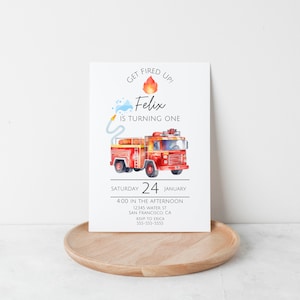 May include: A red fire engine with a blue water hose and a red flame illustration. The text "GET FIRED UP!" is above the fire engine and the text "Felix is turning one" is below the fire engine. The text "SATURDAY 24 JANUARY" is below the fire engine. The text "4:00 IN THE AFTERNOON" is below the date. The text "12345 WATER ST SAN FRANCISCO, CA" is below the time. The text "RSVP TO ERICA 555-555-5555" is below the address.