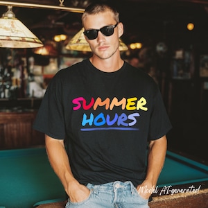 May include: A black short-sleeved t-shirt featuring the text "SUMMER HOURS" printed in a multi-colored gradient font across the chest. The word "SUMMER" appears in pink, orange, and yellow, while "HOURS" is in shades of blue and purple.