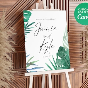 Może przedstawiać: Biały znak ślubny z zielonymi liśćmi akwarelowymi i tekstem "Witamy na ślubie Jamiego i Kyle'a 5.04.23".