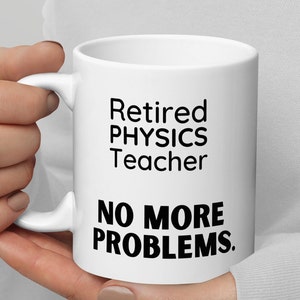 May include: White ceramic coffee mug with black text that reads "Retired Physics Teacher No More Problems."