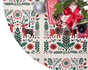 May include: A white and cream Christmas tree skirt with a red, green, and black Scandinavian folk art pattern. The pattern features stylized reindeer, flowers, and trees. The skirt is decorated with red and white gift boxes, pine cones, and a silver ornament.