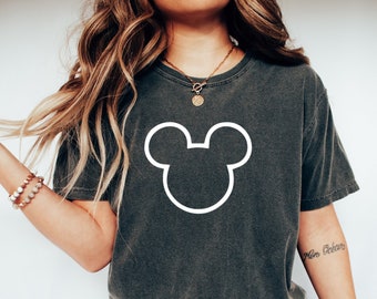 Könnte beinhalten: Ein dunkelgraues T-Shirt mit einer weißen Umrandung von Mickey Mouse' Kopf. Die Person, die das Shirt trägt, trägt auch eine blaue Jeans und weiße Turnschuhe.