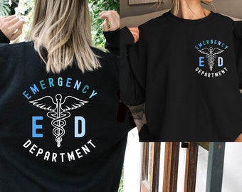 Puede incluir: Sudadera negra con un gráfico blanco de un símbolo de caduceo médico y el texto "Emergency Department" en un círculo a su alrededor.