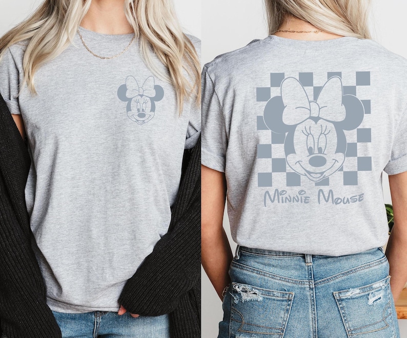 Pu&ograve; includere: Maglietta grigia con un design a scacchi bianco e nero con una grafica di Minnie Mouse grigia e il testo "Minnie Mouse".