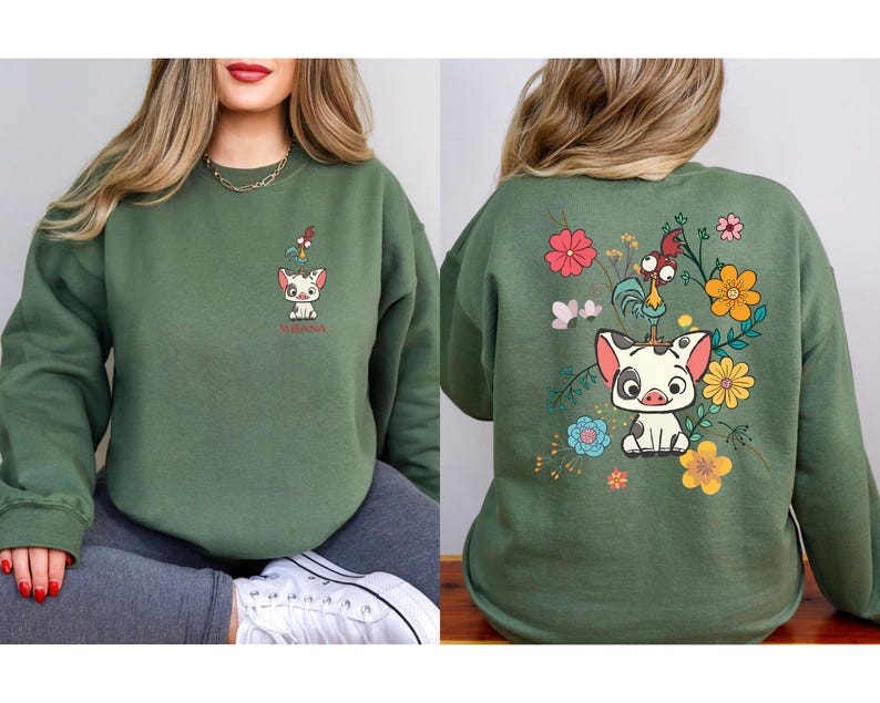 K&ouml;nnte beinhalten: Gr&uuml;nes Sweatshirt mit einem Cartoon-Schwein- und Hahn-Design. Auf der Vorderseite befindet sich eine kleine Grafik des Schweins mit dem Wort "Vaiana". Auf der R&uuml;ckseite befindet sich eine gr&ouml;&szlig;ere Grafik des Schweins, des Hahns und der Blumen.