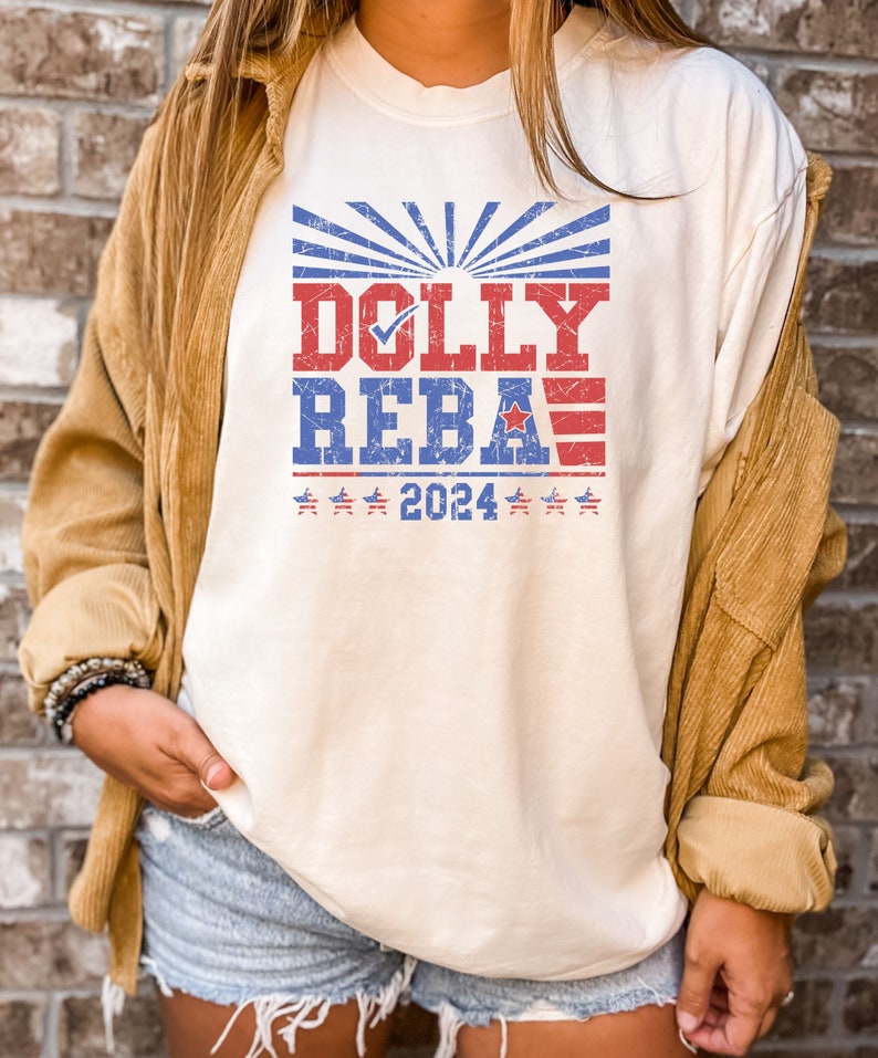 May include: A white t-shirt with a vintage-style graphic that says "DOLLY REBA 2024" with red, white, and blue stars and stripes.