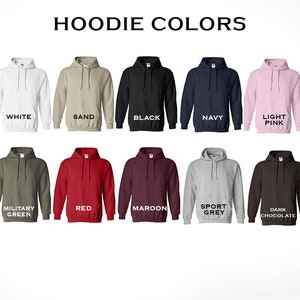 May include: A selection of ten hooded sweatshirts in various colors, including white, sand, black, navy, light pink, military green, red, maroon, sport grey, and dark chocolate. The text "HOODIE COLORS" is displayed at the top of the image.