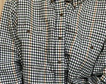 May include: A white button-down shirt with a green, brown, and blue plaid pattern. The shirt has a long sleeve and a collar.