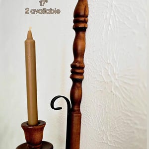May include: Vintage wooden wall candlestick holder, 17 inches tall, with a brown candle. The holder has a dark brown finish and a decorative black metal accent. The text "Vintage Wooden wall Candlestick Holder 17" 2 available" is visible.