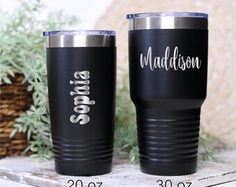 May include: Two black insulated tumblers with silver lids. One tumbler has the name "Sophia" in a silver script, and the other has "Maddison". The first tumbler is 20 oz, and the second is 30 oz.