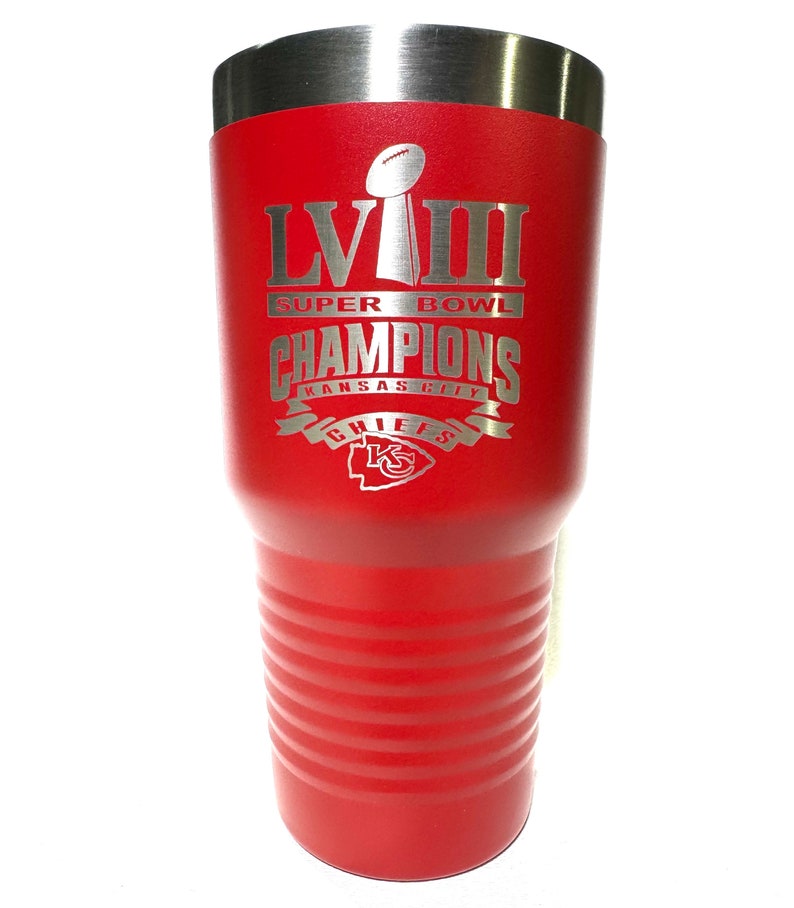 May include: Red insulated tumbler with a silver lid. The tumbler features the text "LVIII Super Bowl Champions Kansas City Chiefs" in silver lettering, along with the Super Bowl trophy and the Chiefs logo.