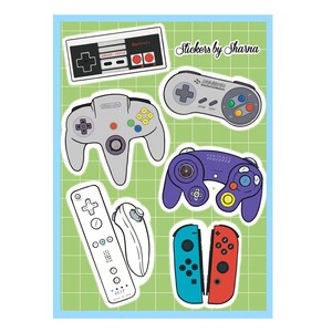 May include: A set of six colorful video game controller stickers. The stickers feature a variety of controllers, including the Nintendo Entertainment System, Super Nintendo Entertainment System, Nintendo 64, GameCube, Wii, and Nintendo Switch. The stickers are all on a green grid background. Stickers by Sharna.