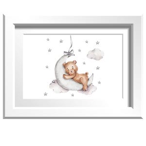 Puede incluir: Una impresión enmarcada con una ilustración de acuarela de un osito de peluche durmiendo en una luna creciente. El oso es marrón claro, la luna es gris y el fondo tiene estrellas y nubes. El marco es blanco.