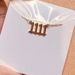 May include: A gold necklace with a Roman numeral pendant that reads "IIII".