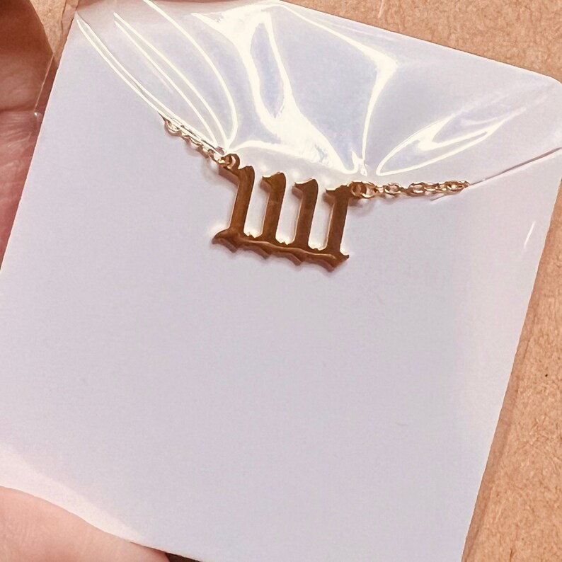 May include: A gold necklace with a Roman numeral pendant that reads "IIII".