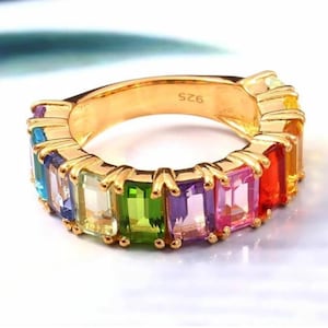 May include: Gold ring with a rainbow of colorful rectangular gemstones. The ring is marked with the number "925".