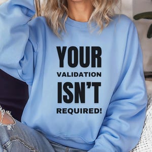 May include: A light blue sweatshirt with the text "YOUR VALIDATION ISN'T REQUIRED!" printed in black.