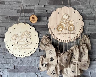 May include: Wooden advent calendar featuring a rocking horse and a bear on a bicycle. The bear wears a sweater and rides a bicycle with a basket. Includes small burlap bags numbered 1-24 for each day of advent.