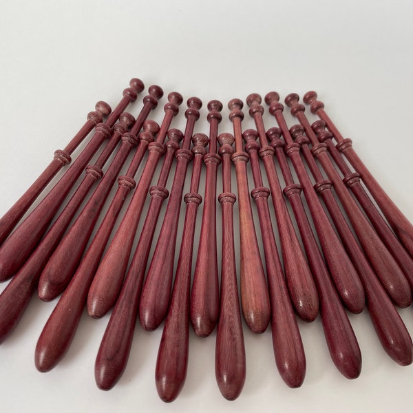 Twenty turned and polished purpleheart  Bayeux Bobbins .