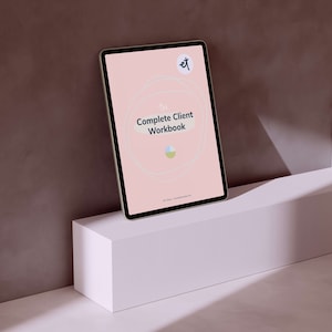 Puede incluir: Una tableta digital que muestra "The Complete Client Workbook" sobre un fondo rosa. La tableta está apoyada en un pedestal geométrico blanco contra un fondo marrón. La portada del cuaderno presenta un diseño circular y un logotipo.