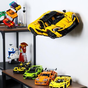 May include: A collection of yellow, orange, green, and black toy cars. The cars are made of plastic and have a variety of designs. The cars are displayed on a shelf with a white background.