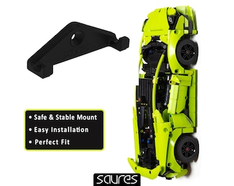 Puede incluir: Un soporte de pared de plástico negro con un gancho para colgar un modelo de coche Lego. El soporte está diseñado para ser seguro, estable y fácil de instalar. El modelo de coche es un coche deportivo Lego verde brillante.