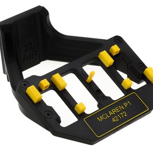 May include: Black plastic stand with yellow plastic pieces and the text "McLaren P1 42172" printed on the front.
