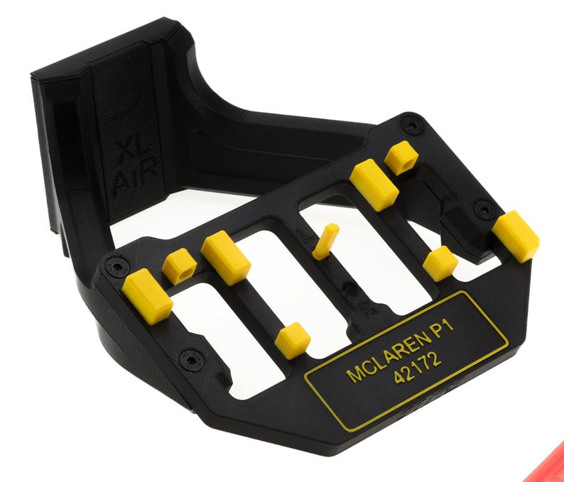 May include: Black plastic stand with yellow plastic pieces and the text "McLaren P1 42172" printed on the front.