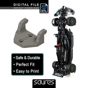 Könnte beinhalten: Eine graue 3D-gedruckte Halterung mit zwei gebogenen Armen und zwei Löchern, neben einem schwarzen und tealfarbenen Modellauto. Der Text auf dem Bild lautet "DIGITAL FILE INSTANT DOWNLOAD STL" und "Safe & Durable, Perfect Fit, Easy to Print."