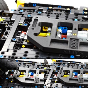 May include: Close-up of a black Lego Technic model with yellow, blue, and gray pieces. The model is partially assembled and shows the intricate details of the gears and mechanisms.