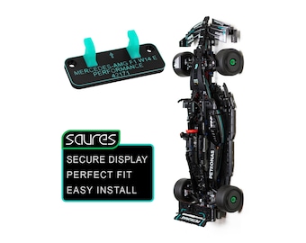 May include: A black Mercedes-AMG F1 W14 E Performance model car with black tires and green accents, accompanied by a black mounting bracket featuring two teal clips and the text MERCEDES-AMG F1 W14 E PERFORMANCE 42171.