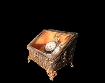 Watch holder/jewelry box on legs, France ca 1910, hammered copper with hunting scene, facet glass lid