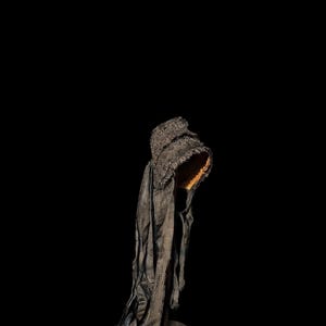 Puede incluir: Un gorro de encaje negro con un borde rizado. El gorro est&aacute; en un soporte y est&aacute; inclinado hacia un lado.