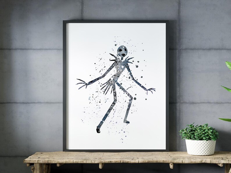 Puede incluir: Impresi&oacute;n art&iacute;stica enmarcada con una ilustraci&oacute;n en acuarela de una figura alta y delgada con cabeza redonda y extremidades alargadas. La figura es en tonos azules y grises, con efectos de pintura salpicada. La obra de arte se exhibe sobre una superficie de madera.