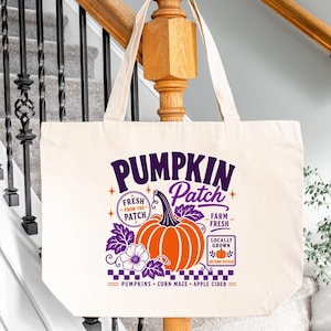 May include: A natural-colored canvas tote bag featuring a graphic print with the text PUMPKIN Patch, FRESH FROM THE PATCH, FARM FRESH, LOCALLY GROWN, AUTUMN PICKED, PUMPKINS, CORN MAZE, and APPLE CIDER, centered around a large orange pumpkin illustration.